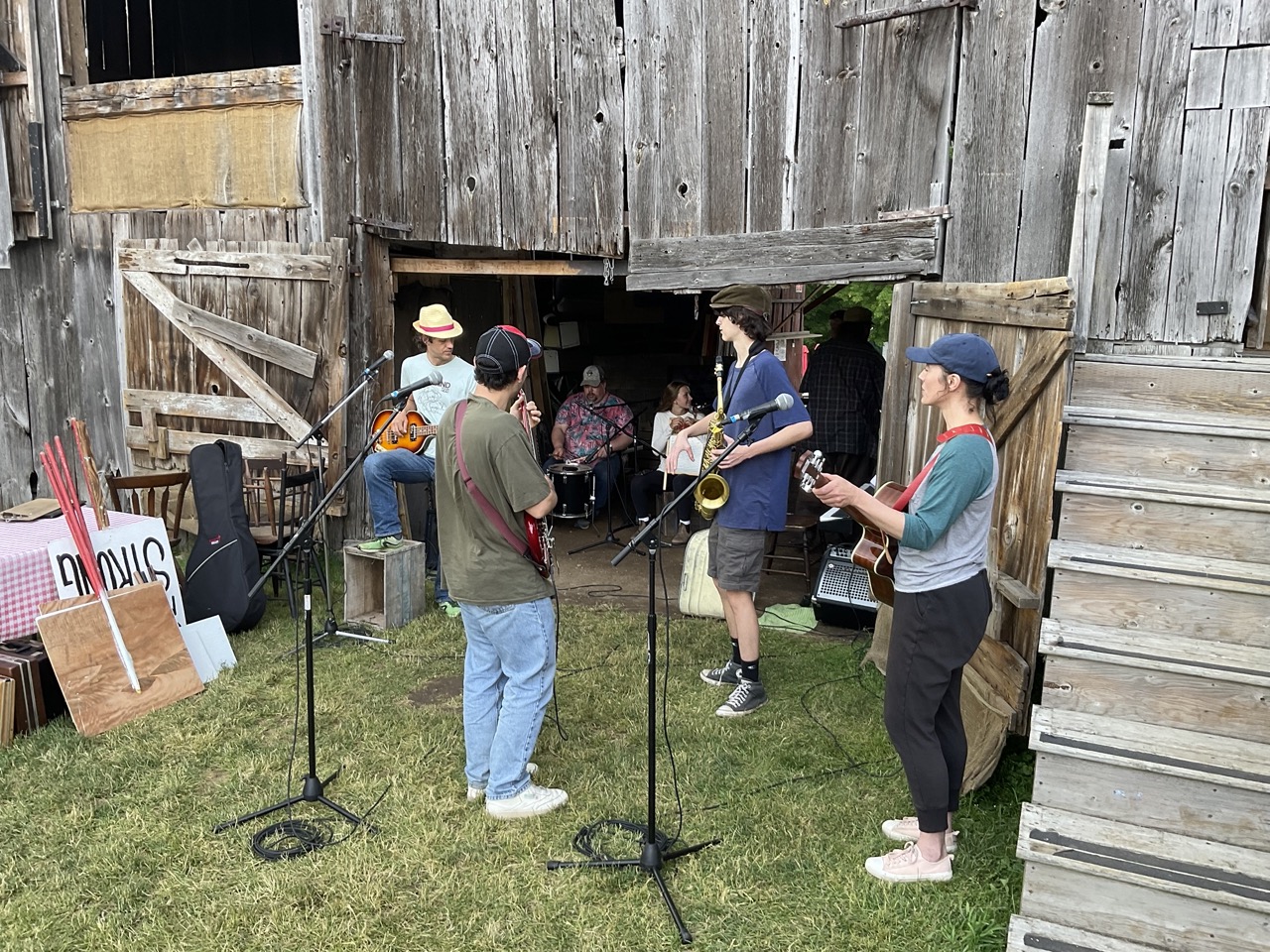 Musicians prep for the show, they are outside adjusting microphone stands and holding saxophones 